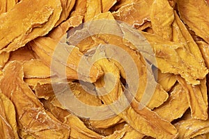 Dried mango chips close up full frame as background
