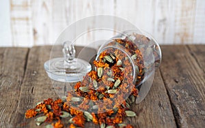 Dried marigold flowers in a glass jar for storage on a wooden background. The use of flowers Chernobrovtsy or Mary is Gold in folk