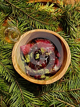 Dried meat with red berries in a wooden saucer