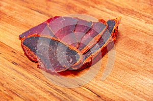 Dried meat with spices on the wooden background