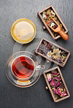 Dried medicinal herbs in wooden boxes and herbal healing tea,
