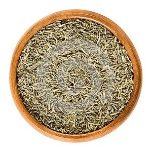 Dried minced thyme in wooden bowl over white