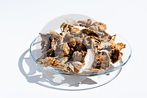 dried mushrooms in a glass bowl isolated on white