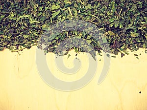 Dried nettle leaves on wooden board with copy space