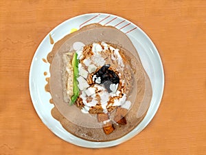 Dried noodle dish with beans, chipotle and natural cream, accompanied with cheese, avocado and pieces of crusty bread