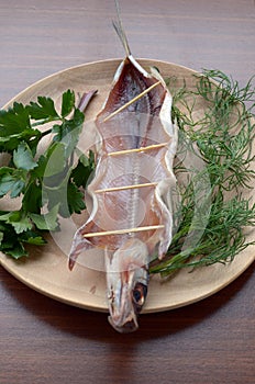 Dried omul on the wooden plate, decorated with verdure