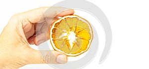 Dried orange slice isolated on white background. Hand holding dried citrus fruit