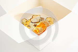 Dried oranges,bananas and apples in white box on white background