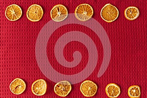 Dried oranges on a red waffle background with copy space for your text. Christmas i new year concept. Vegan concept.