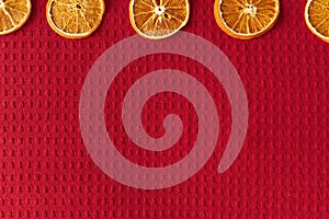 Dried oranges on a red waffle background with copy space for your text. Christmas i new year concept. Vegan concept.