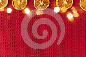 Dried oranges on a red waffle background with copy space for your text. Christmas and new year concept. Vegan concept.