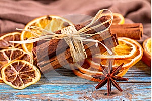 Dried oranges, star anise, cinnamon sticks on blue wooden background - Christmas composition, still life