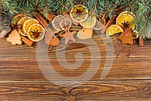 Dried oranges, star anise, cinnamon sticks and gingerbread on a wooden background -- Christmas background