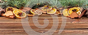 Dried oranges, star anise, cinnamon sticks and gingerbread on a wooden background -- Christmas background, banner