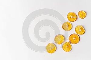 Dried oranges on a white background with christmas lights and copy space. Healthy sweets concept. Flat lay