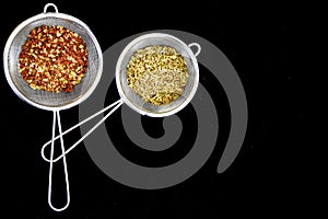 Dried oregano herbs , Various spices on spoons on black background, copy space