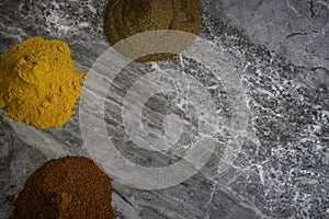 Dried organic spice powders on a marble kitchen worktop background photographed from above