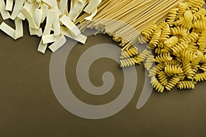 Dried pasta on the brown surface.Empty space for text