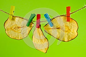 Dried pear chips, closeup shot on a green background. Background for a healthy diet