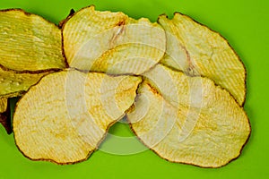 Dried pear chips, closeup shot on a green background. Background for a healthy diet