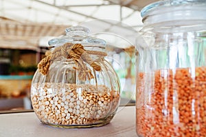 Dried peas in a glass jar decorated with a rope bow. Retro style. Selective focus