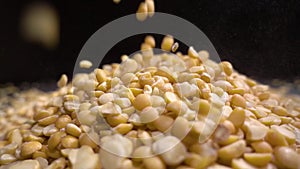 Dried peas are poured on a table, black background.