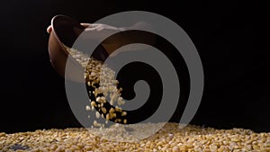 Dried peas are poured on a table, black background.