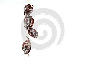 Dried persimmon dries on a rope isolated on white