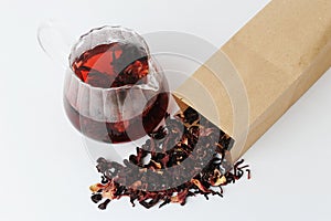 Dried petals pomegranate flowers tea is brewed in a glass teapot. Beautiful ruby infusion. Flower drink, healthy food