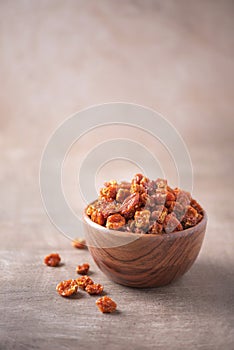 Dried physalis in wooden bowl on wood textured background. Copy space. Superfood, vegan, vegetarian food concept. Macro of inca