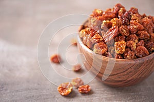 Dried physalis in wooden bowl on wood textured background. Copy space. Superfood, vegan, vegetarian food concept. Macro of inca