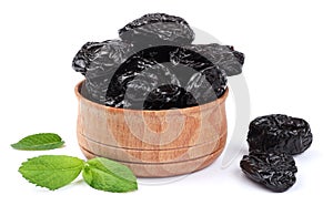 Dried plums - prunes in wooden bowl isolated on white