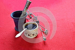 Dried poppy capsules, seeds in a cup and mortar with pestle