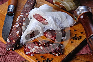 Dried pork sausages composition on a wooden background