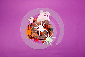 dried potpourri with colorful spiders and ghosts, creative halloween concept, flat lay, paper craft, purple background