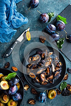 Dried prune and fresh plums with leaves