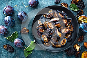 Dried prune and fresh plums with leaves