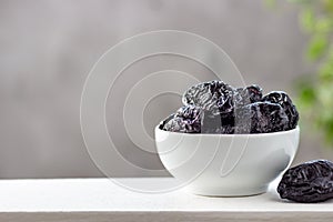 Dried prunes in a white bowl