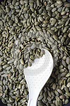 Dried pumpkin seeds and a white spoon