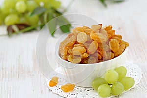 Dried raisins in a bowl and fersh grape