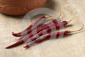 Dried raw Mexican chile de Arbol peppers on wooden background photo