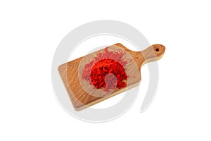 Dried Red Chili Pepper or Paprika powder on wooden cutting board on white background. Red pepper ground, hot spices