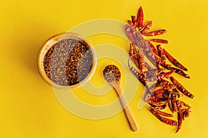 Dried red chili peppers Guajillo and chili powder spice on yellow background
