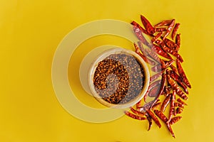 Dried red chili peppers Guajillo and chili powder spice on yellow background photo
