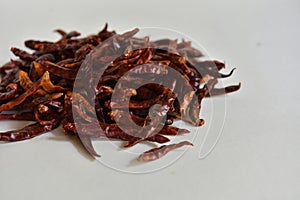 Dried red chilli seeds are an ingredient in cooking, placed on a white background.