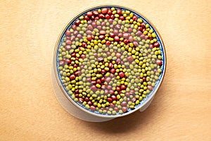 Dried red and green beans mixed in one bowl on wooden background