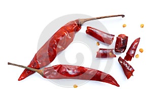 Dried red hot chili pepper, dried chili flakes and seeds pile on a white background.