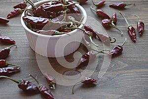 Dried red hot chilly peppers, very spicy on wooden table.