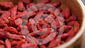 Dried red wolfberries goji berry in wooden rustic bowl close up.