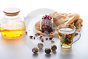dried rose buds in jar cup of chinese flowering tea with tea balls